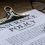 insurance policy on clipboard with pen and glasses